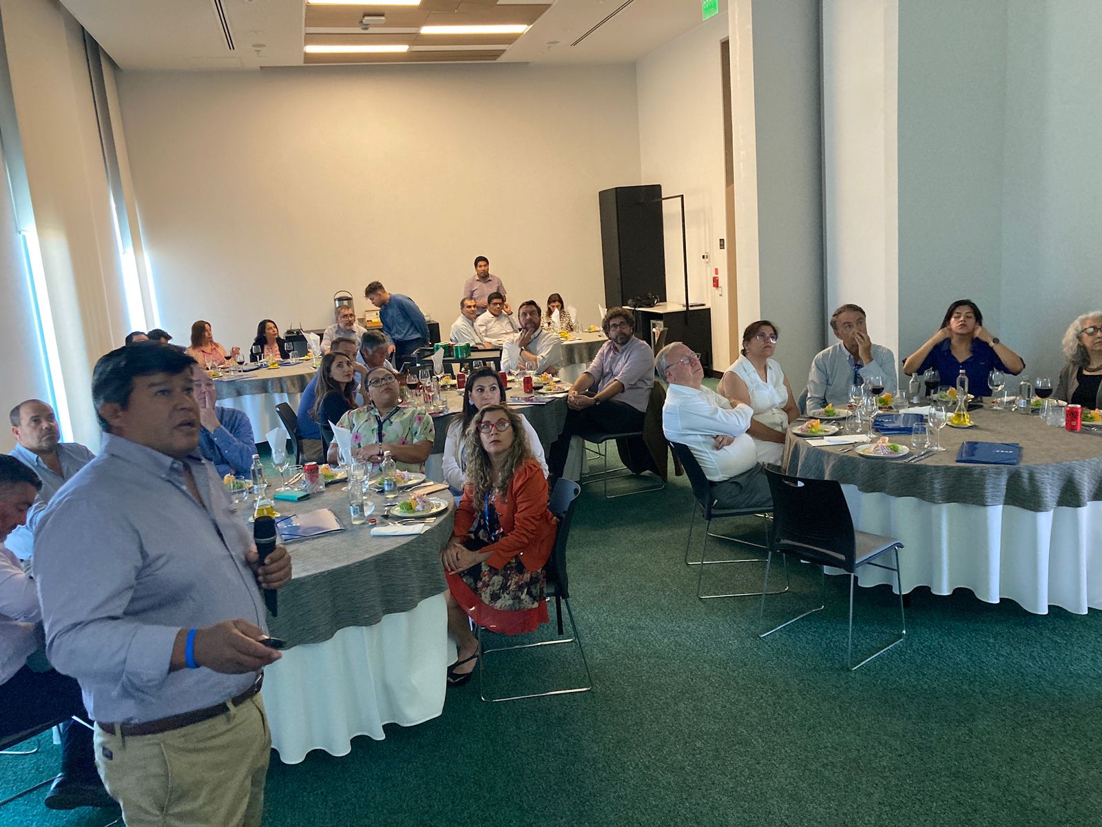 Socios participantes disfrutan un almuerzo en la sede de la CChC Arica mientras un expositor presenta el plan de la campaña Arica 2019